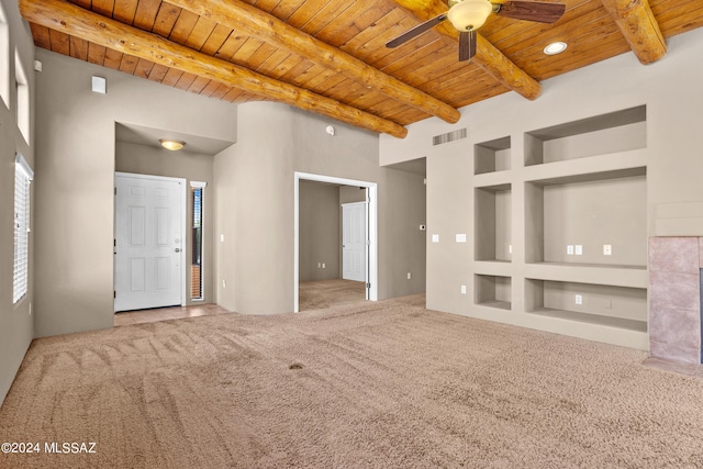 unfurnished living room featuring beam ceiling, wood ceiling, carpet flooring, and ceiling fan