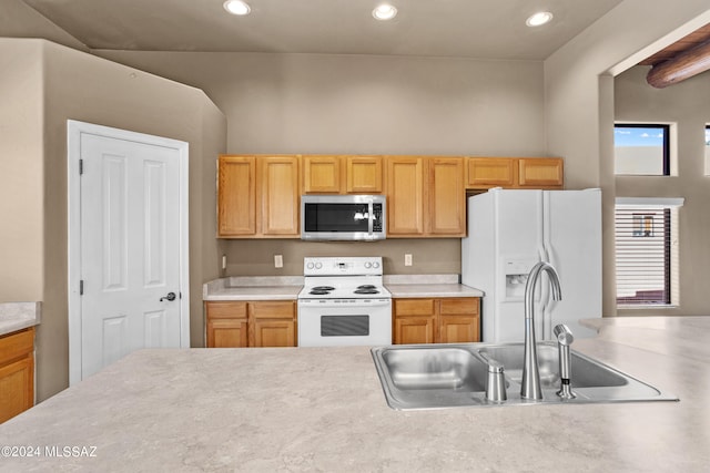 kitchen featuring light brown cabinets, sink, and white appliances