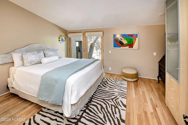 bedroom featuring light hardwood / wood-style flooring, french doors, and access to exterior