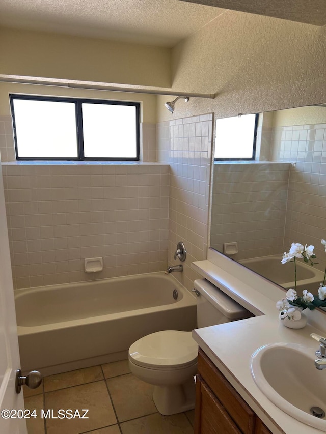 full bathroom featuring toilet, plenty of natural light, and tiled shower / bath