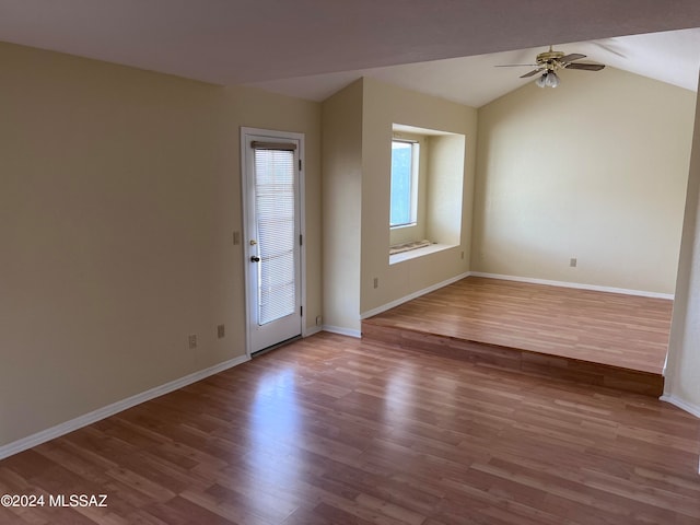 empty room with hardwood / wood-style floors, vaulted ceiling, and ceiling fan