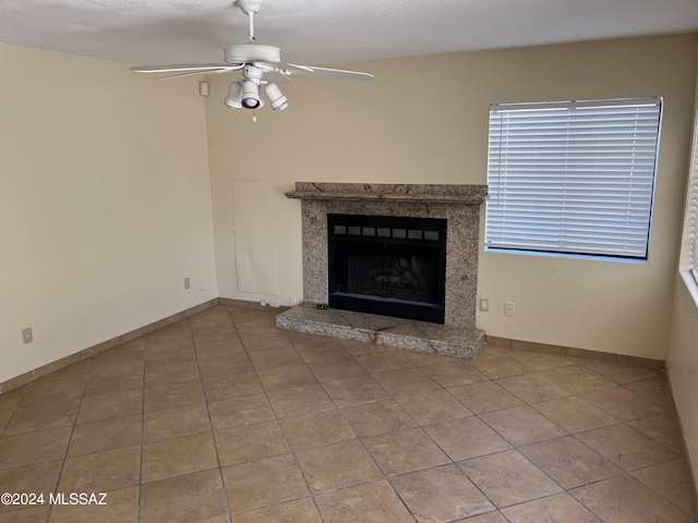 unfurnished living room with a fireplace and ceiling fan