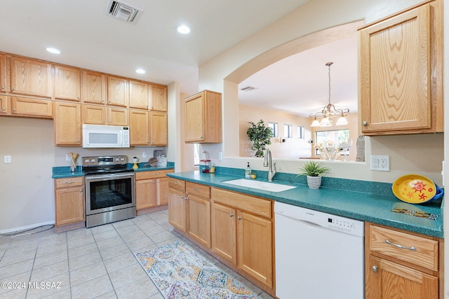 kitchen featuring dark countertops, visible vents, a sink, arched walkways, and white appliances