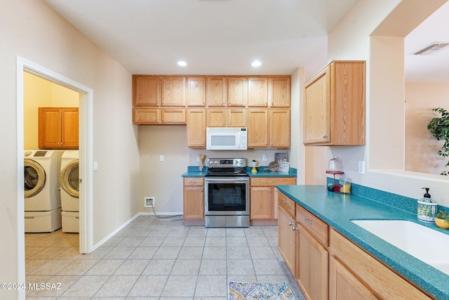 kitchen featuring stainless steel electric stove, washing machine and dryer, visible vents, white microwave, and light tile patterned floors