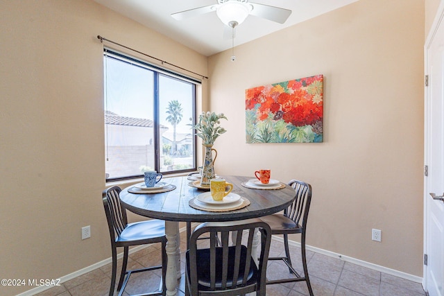 dining area featuring baseboards, a ceiling fan, and light tile patterned floors