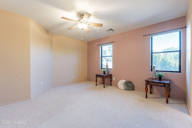 spare room with a ceiling fan, visible vents, and carpet