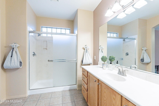 bathroom featuring a shower stall, a healthy amount of sunlight, tile patterned floors, and vanity