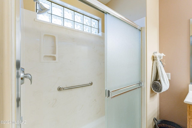 bathroom with a shower with door