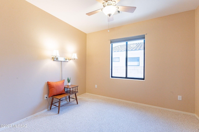 living area featuring a ceiling fan, baseboards, and light carpet