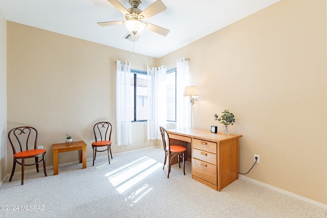 office space featuring light carpet, a ceiling fan, and baseboards