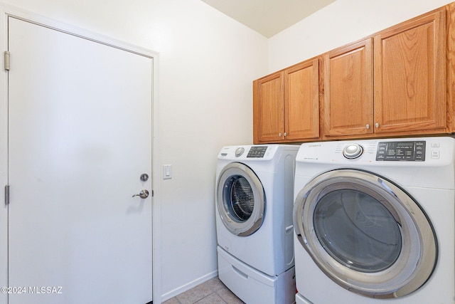 clothes washing area with light tile patterned floors, separate washer and dryer, and cabinets