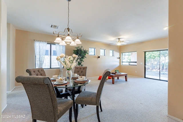 dining room featuring baseboards, carpet floors, visible vents, and ceiling fan with notable chandelier