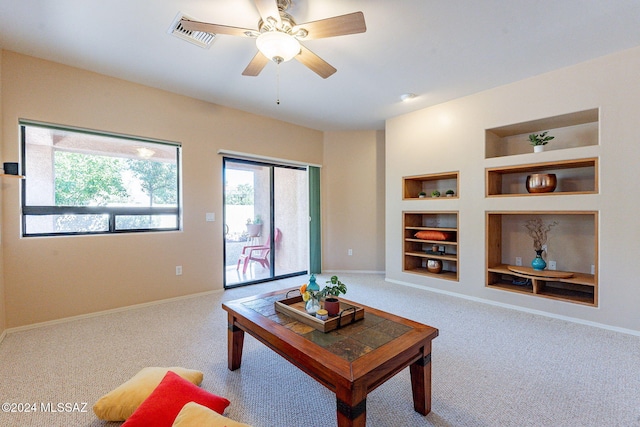 carpeted living room featuring ceiling fan and built in features