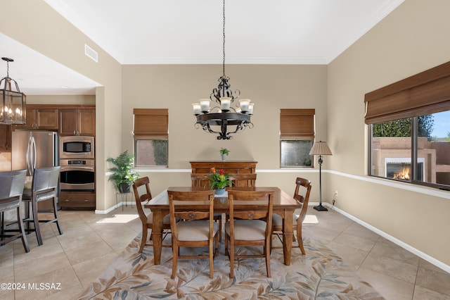 dining room featuring light tile patterned flooring, a chandelier, and a fireplace