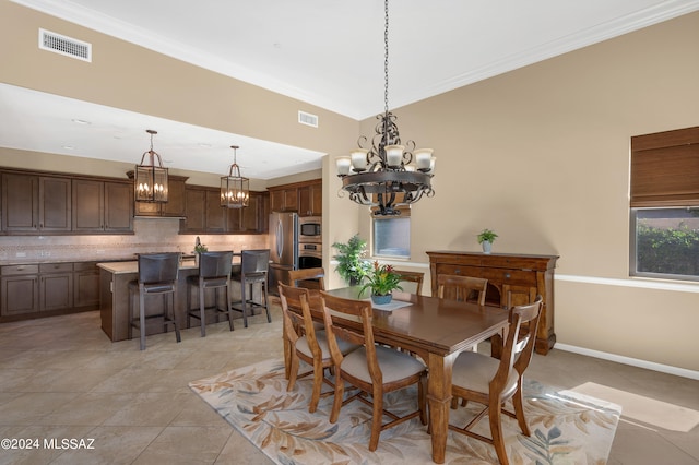 tiled dining area with crown molding and a chandelier