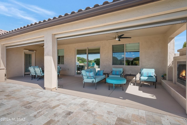 view of patio with a fireplace and ceiling fan