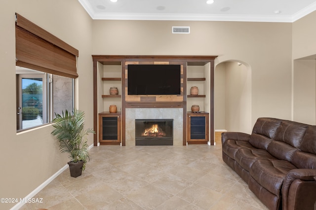 living room featuring crown molding and a tile fireplace