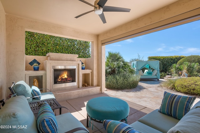 view of patio featuring an outdoor living space with a fireplace and ceiling fan