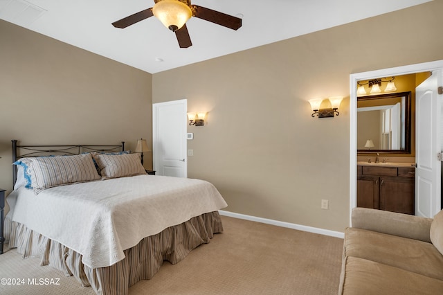 carpeted bedroom with ensuite bathroom, sink, and ceiling fan