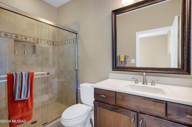 bathroom with vanity, toilet, and a shower with shower door