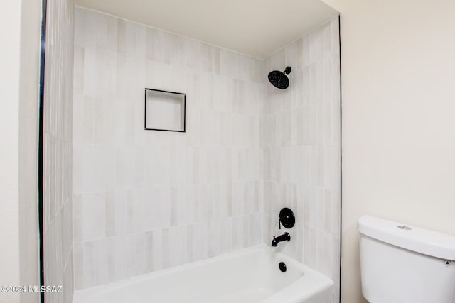 bathroom featuring tiled shower / bath and toilet