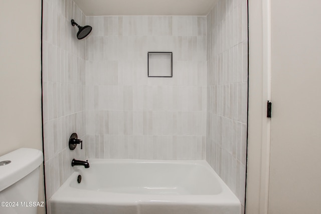 bathroom featuring toilet and tiled shower / bath