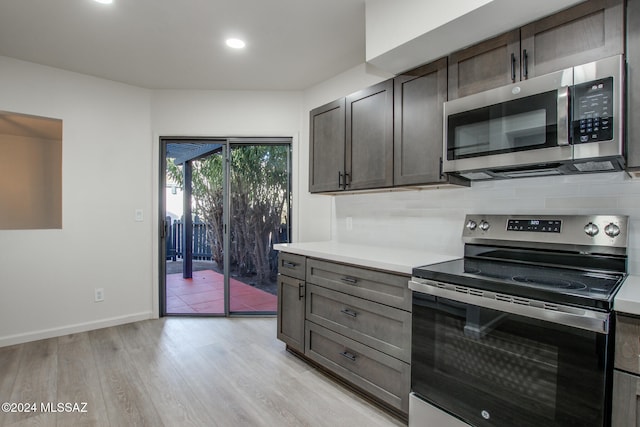 kitchen featuring appliances with stainless steel finishes, backsplash, light hardwood / wood-style floors, and dark brown cabinets