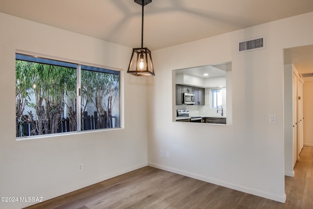 unfurnished dining area with sink and hardwood / wood-style flooring