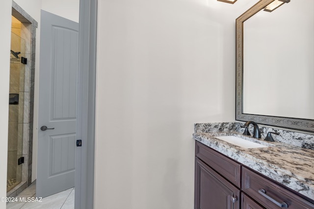 bathroom with a shower with door, tile patterned floors, and vanity