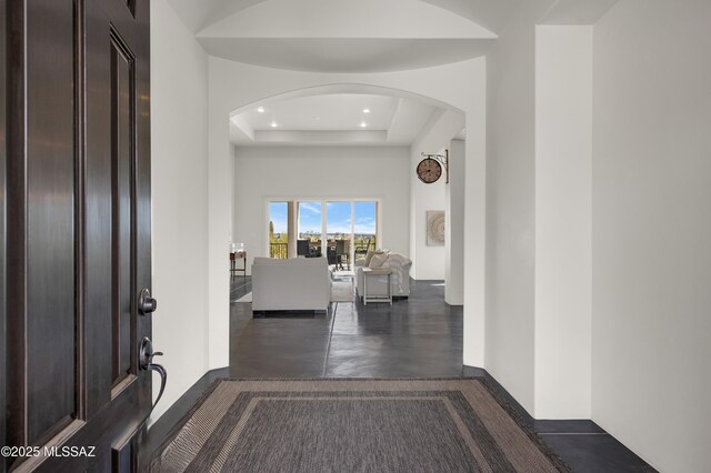 foyer with a raised ceiling and a chandelier