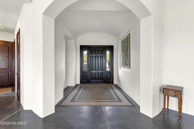 entrance foyer with lofted ceiling, a chandelier, and dark hardwood / wood-style flooring