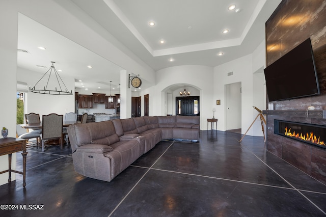 living room featuring a tray ceiling and a tile fireplace