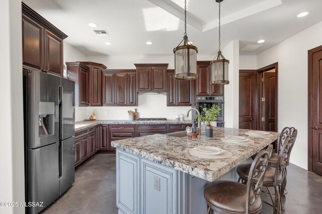 kitchen featuring sink, double oven, light stone counters, and stainless steel gas stovetop