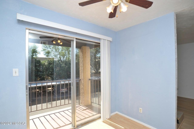 doorway with wood-type flooring and ceiling fan