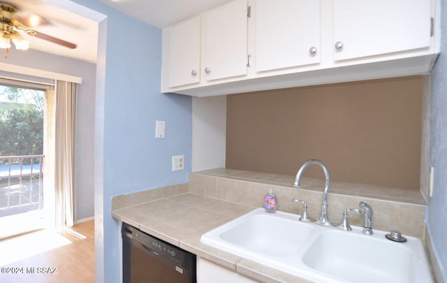 kitchen with sink, dishwasher, white cabinetry, tile counters, and light hardwood / wood-style flooring