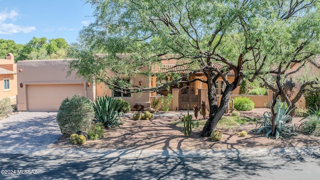 pueblo revival-style home featuring a garage