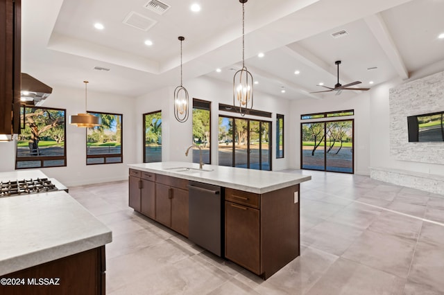 kitchen with an island with sink, hanging light fixtures, sink, stainless steel dishwasher, and ceiling fan with notable chandelier