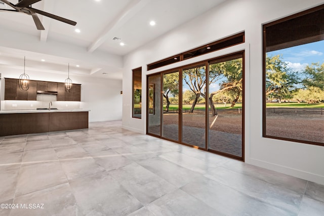 kitchen featuring dark brown cabinets, hanging light fixtures, ceiling fan, beamed ceiling, and sink