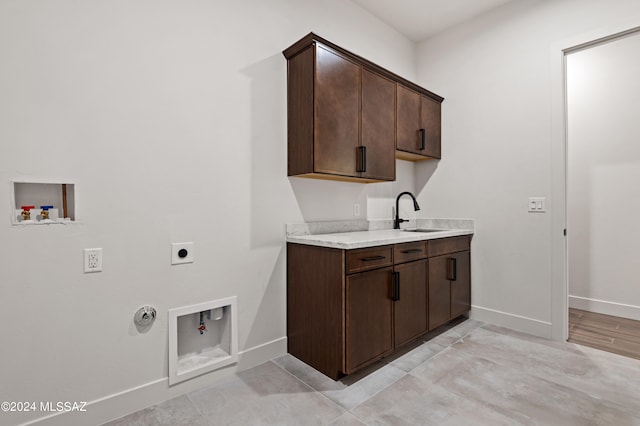 laundry room featuring hookup for an electric dryer, sink, gas dryer hookup, washer hookup, and cabinets