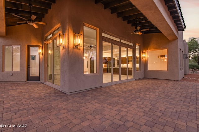 patio terrace at dusk featuring ceiling fan