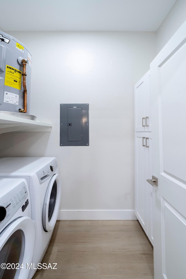 laundry room featuring electric panel, washing machine and clothes dryer, and light hardwood / wood-style flooring