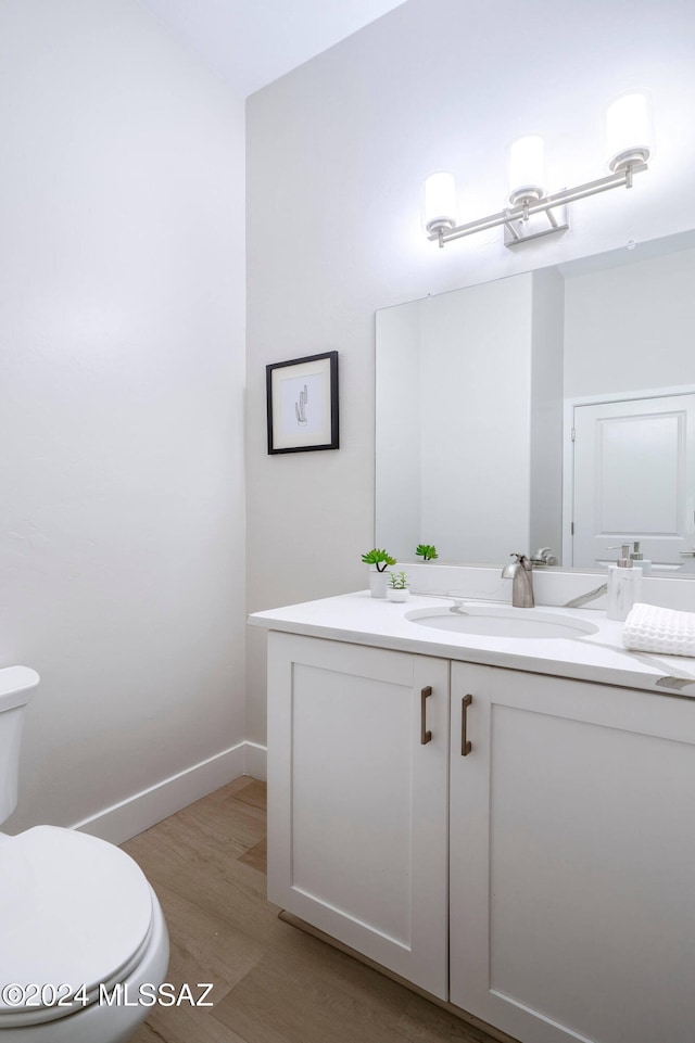 bathroom featuring hardwood / wood-style floors, vanity, and toilet