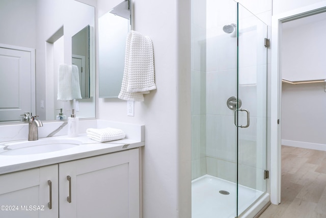 bathroom featuring vanity, hardwood / wood-style flooring, and a shower with shower door