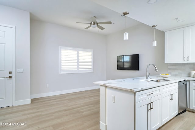 kitchen with light stone counters, sink, white cabinets, dishwasher, and kitchen peninsula