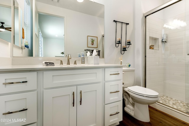 bathroom with vanity, ceiling fan, a shower with door, hardwood / wood-style flooring, and toilet