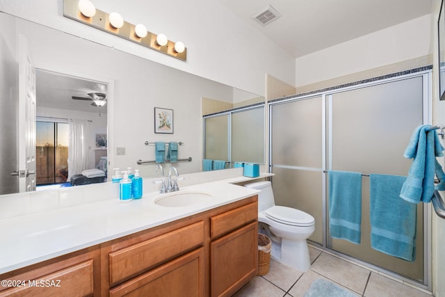 bathroom featuring toilet, vanity, tile patterned flooring, ceiling fan, and a shower with shower door