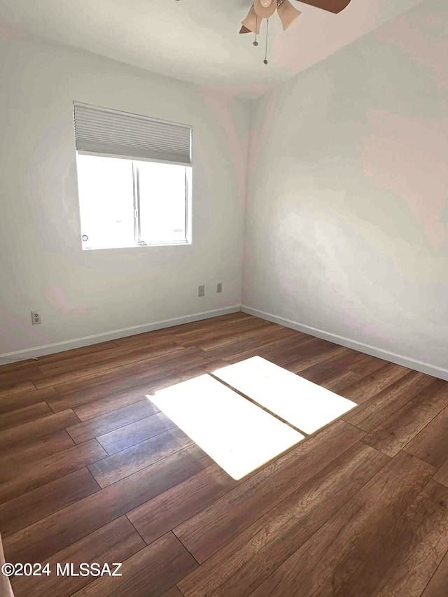 empty room with dark hardwood / wood-style floors and ceiling fan