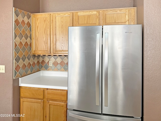 kitchen featuring backsplash and stainless steel refrigerator