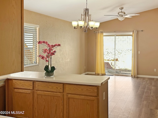 kitchen with light hardwood / wood-style floors, a healthy amount of sunlight, ceiling fan with notable chandelier, and vaulted ceiling