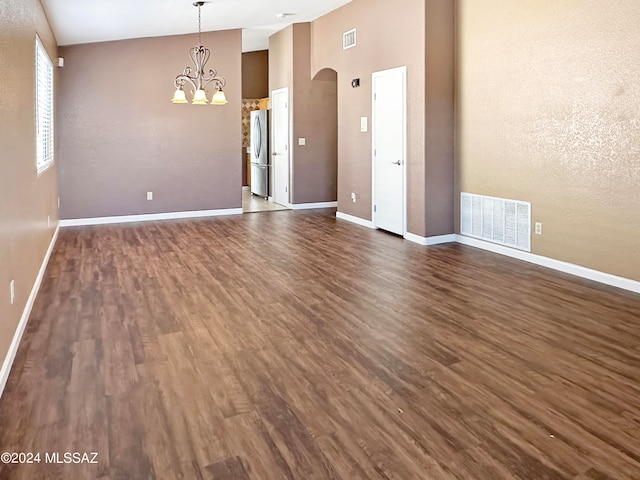 spare room featuring high vaulted ceiling, a notable chandelier, and dark hardwood / wood-style floors